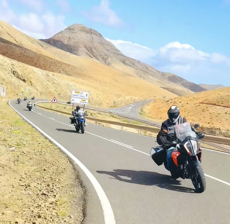 Eine Gruppe von Motorradfahrern auf einer malerischen, kurvigen Straße in Fuerteventura, Kanarische Inseln, während einer geführten Motorradtour von RoadRoom