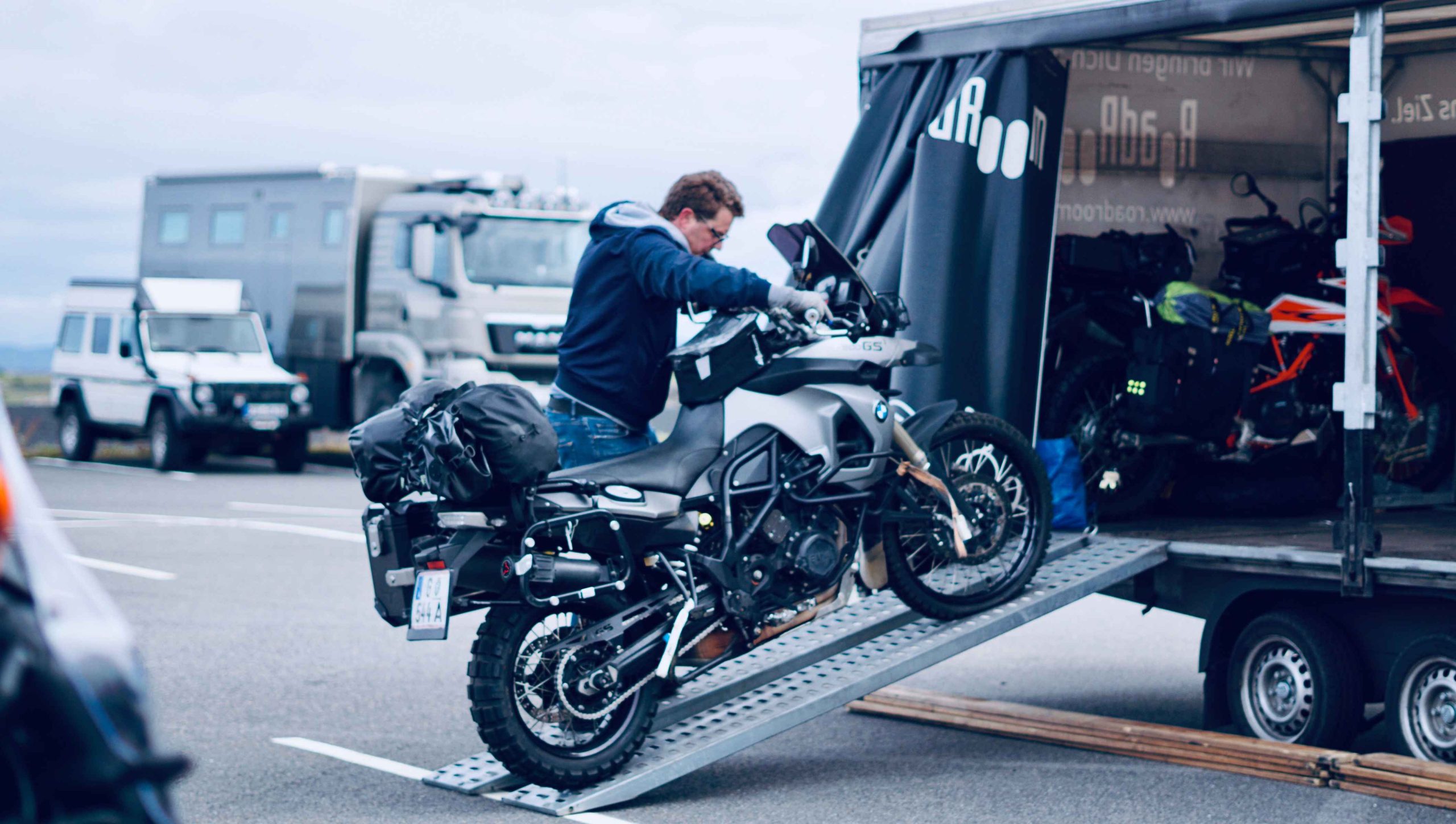 RoadRoom-Anhänger am Flughafen Reykjavik. André entlädt ein aus Deutschland transportiertes Motorrad
