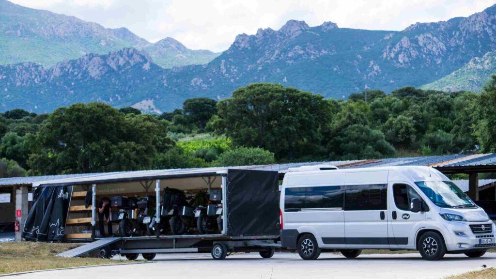 RoadRoom-Van mit Anhänger, voll beladen mit Motorrädern in Sardinien, bereit für den Transport zurück nach Deutschland direkt zu den Häusern unserer Kunden.