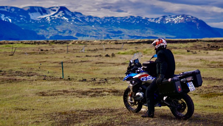 Motorradfahrer blickt während unserer Tour in Island auf den Horizont, umgeben von einer atemberaubenden isländischen Landschaft